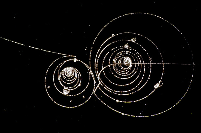 Visual jejak partikel pada halaman pengantar antimateri CERN. Digunakan untuk konteks deteksi partikel; bukan data atau foto positron terperangkap tahun 2026.