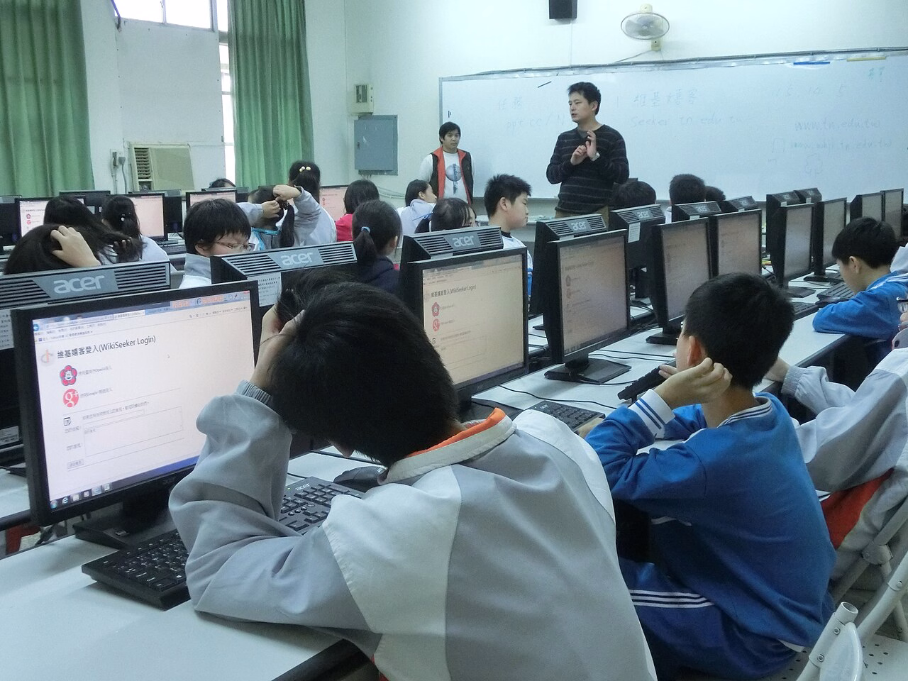 Guru membimbing siswa menggunakan komputer dalam foto arsip kegiatan WikiSeeker